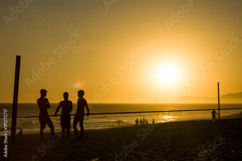silhouette of men talking at the beach during sunset in Rio de Janeiro © jpbarcelos