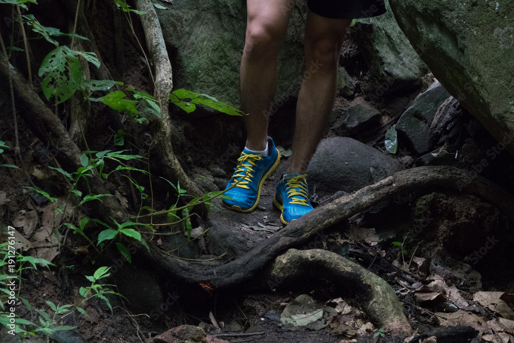 marathon runner running rocks in mountain. closeup of legs compression socks and shoes marathon runner running rocks in mountain. closeup of legs compression socks and shoes