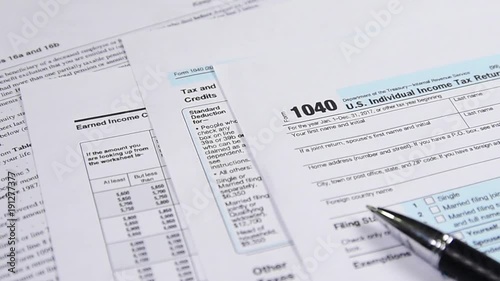 Tax form 1040 and pen on the desk. dolly shot