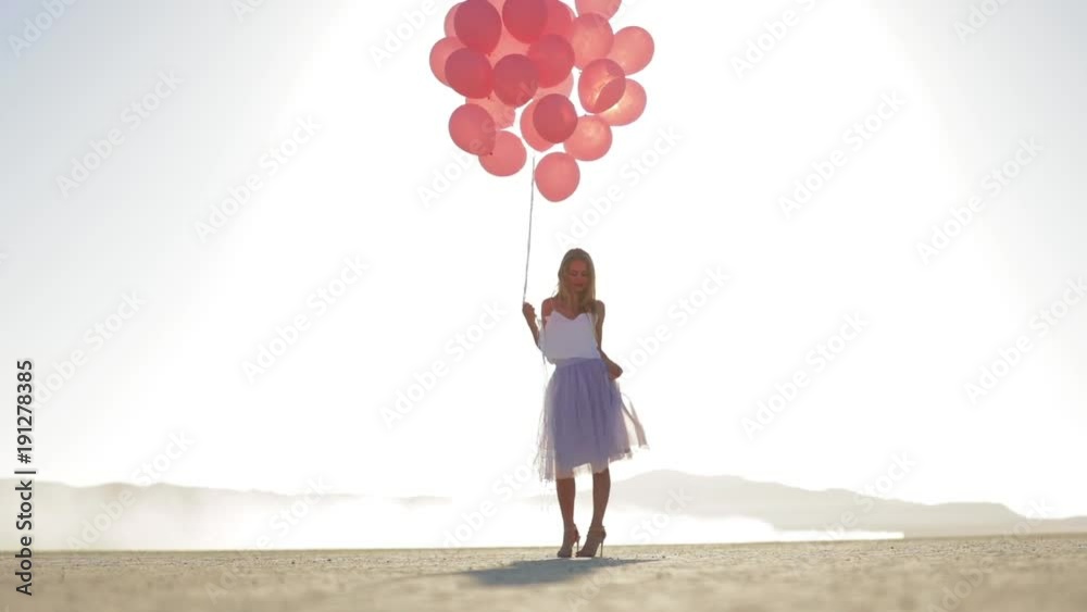 A girl with balloons walking in the desert Lake El Mirage. Slow motion. October 2017 A girl with balloons walking in the desert Lake El Mirage. Slow motion. October 2017