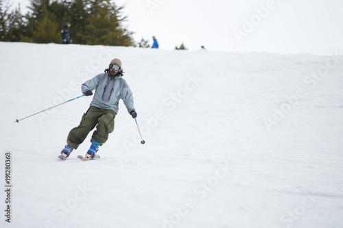 Skier in mountains, prepared piste and sunny day