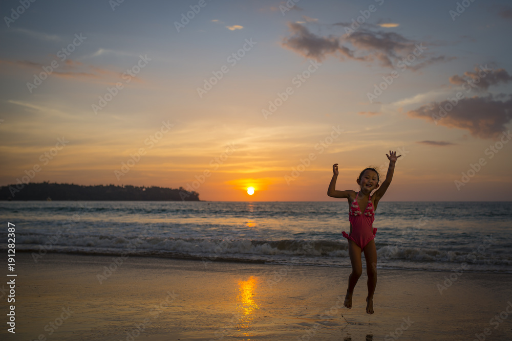 夕暮れのビーチで遊ぶ女の子