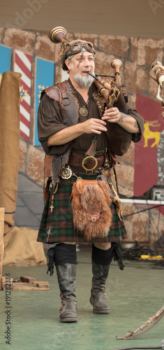 bagpiper is amused while performing at renaissance festival