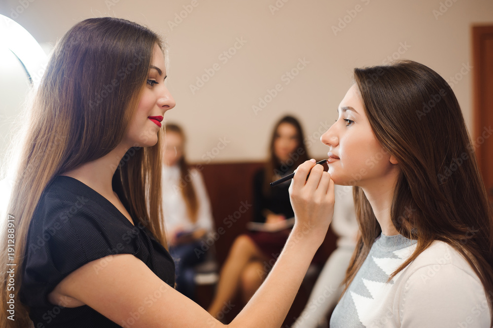 Makeup artist creating beautiful makeup for brunette model Makeup artist creating beautiful makeup for brunette model