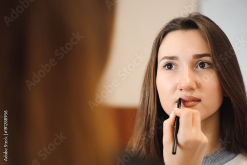 Makeup artist creating beautiful makeup for brunette model