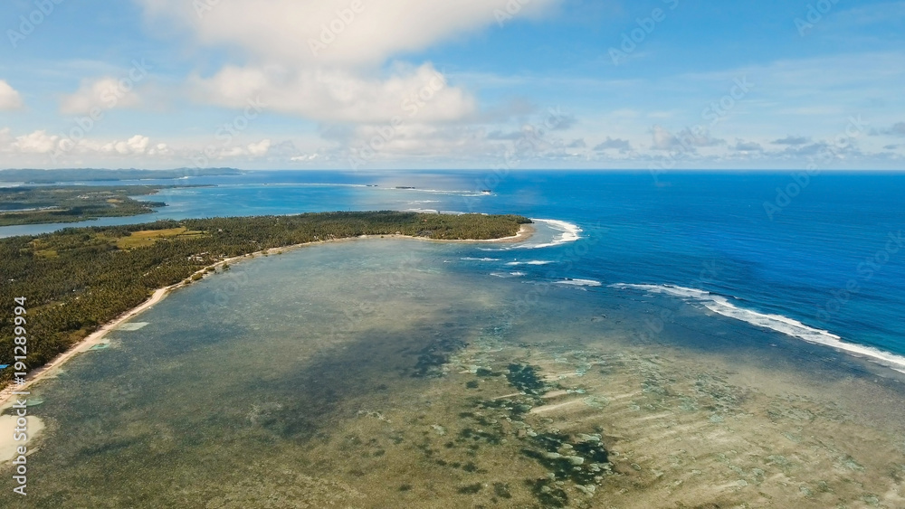 Beautiful tropical island with sand beach, palm trees. Aerial view of tropical beach on the island Siargao, Philippines. Tropical landscape: beach with palm trees. Seascape: Ocean, sky, sea Beautiful tropical island with sand beach, palm trees. Aerial view of tropical beach on the island Siargao, Philippines. Tropical landscape: beach with palm trees. Seascape: Ocean, sky, sea