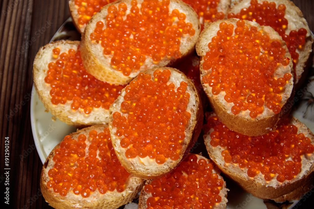 Sandwiches with butter and red caviar on wooden table Sandwiches with butter and red caviar on wooden table
