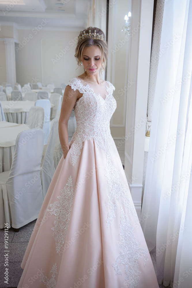 A beautiful woman in a pink wedding dress in a big festive hall A beautiful woman in a pink wedding dress in a big festive hall