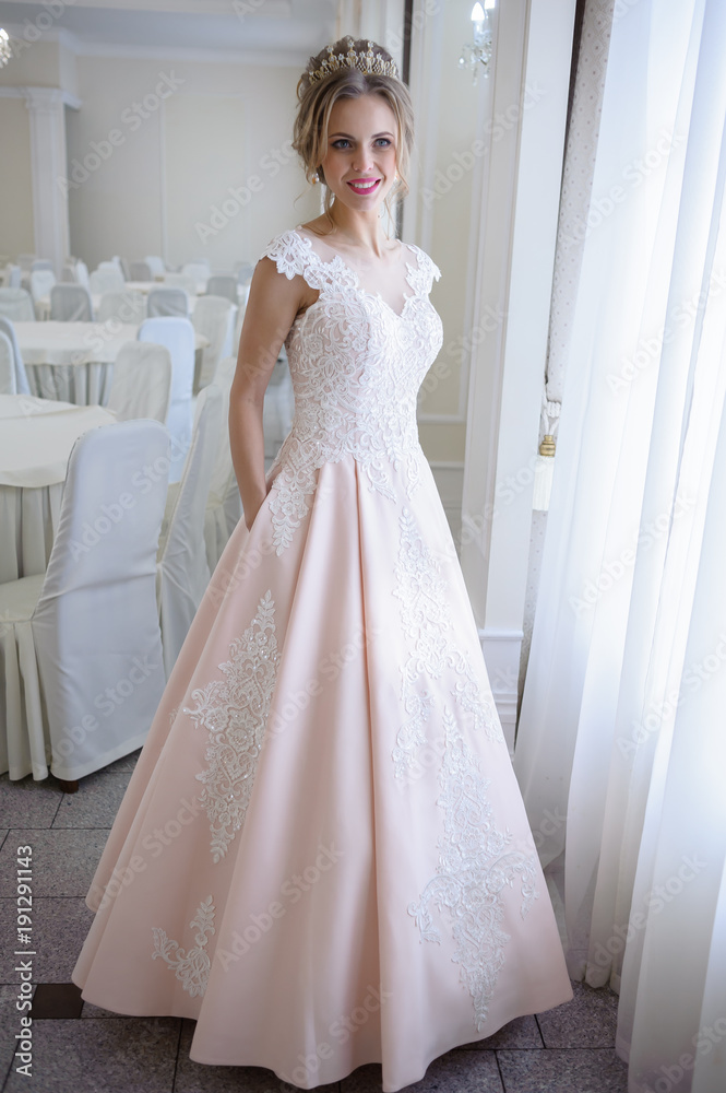 A beautiful woman in a pink wedding dress in a big festive hall A beautiful woman in a pink wedding dress in a big festive hall