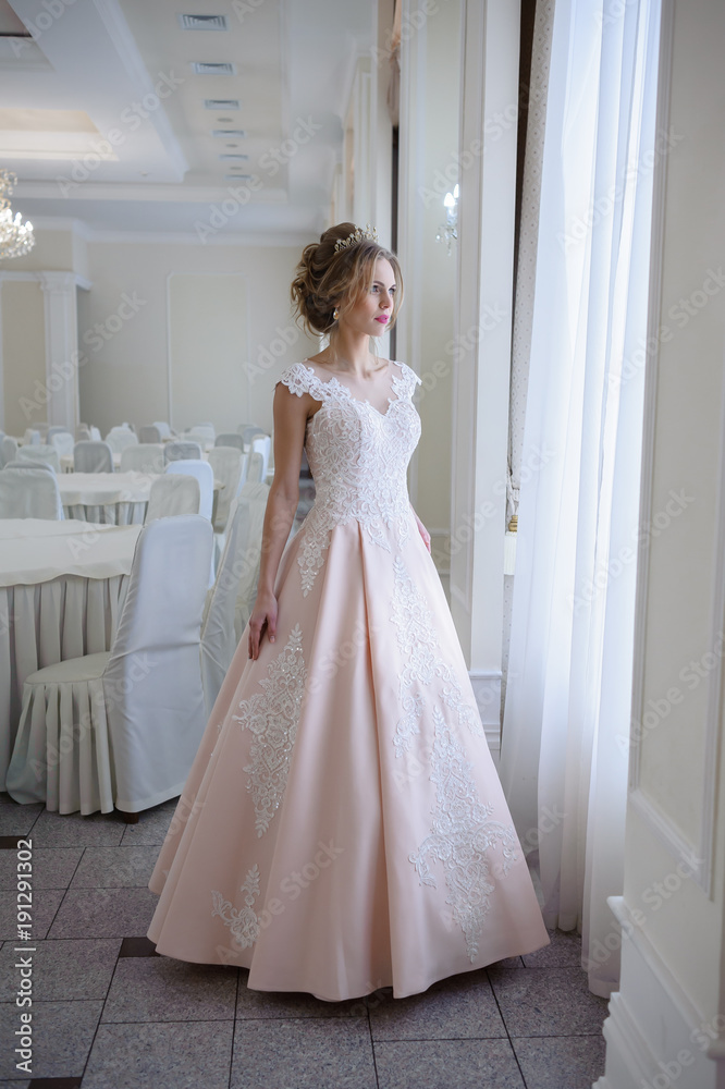A beautiful woman in a pink wedding dress in a big festive hall A beautiful woman in a pink wedding dress in a big festive hall
