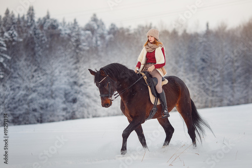 Horse. Jockey girl rider rides brown horse on winter forest in snow. Concept walk in farm. © Parilov