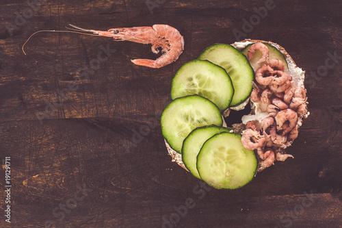 Bagels with cream, shrimps and cucumber slices, top view photo