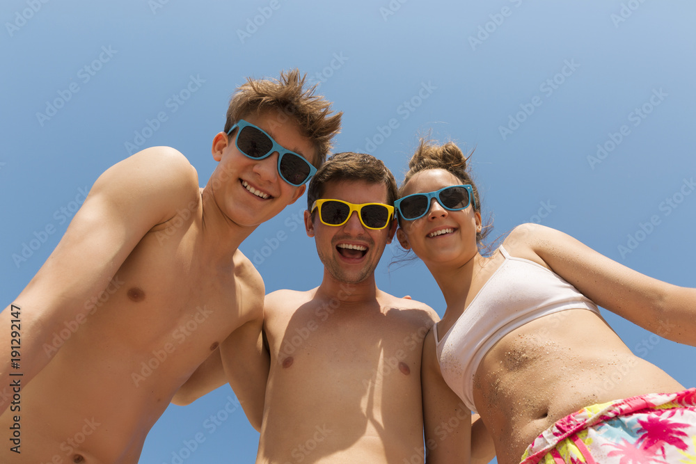 Father and two teenage children in colorful sunglasses laugh Father and two teenage children in colorful sunglasses laugh