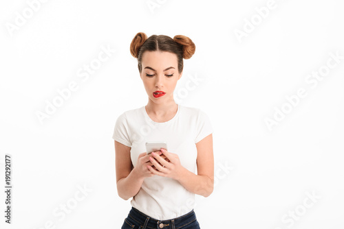 Quadro su tela Portrait of a confused casual girl holding mobile phone