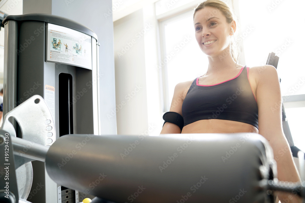 Athletic girl in fitness room lifting weight Athletic girl in fitness room lifting weight