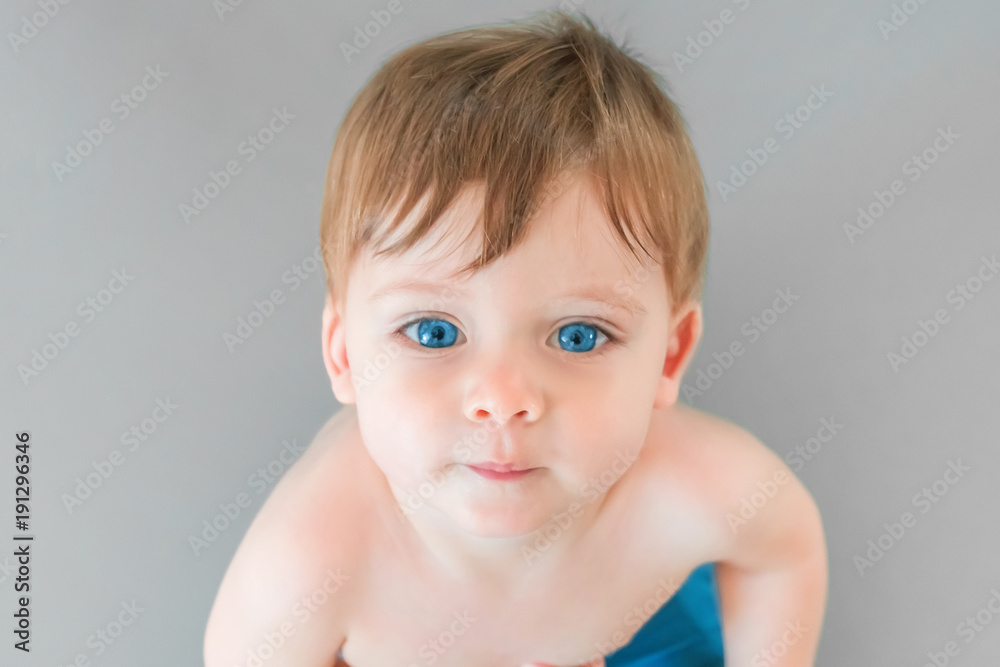 Portrait of a blonde baby boy with blue eyes on a gray background Portrait of a blonde baby boy with blue eyes on a gray background