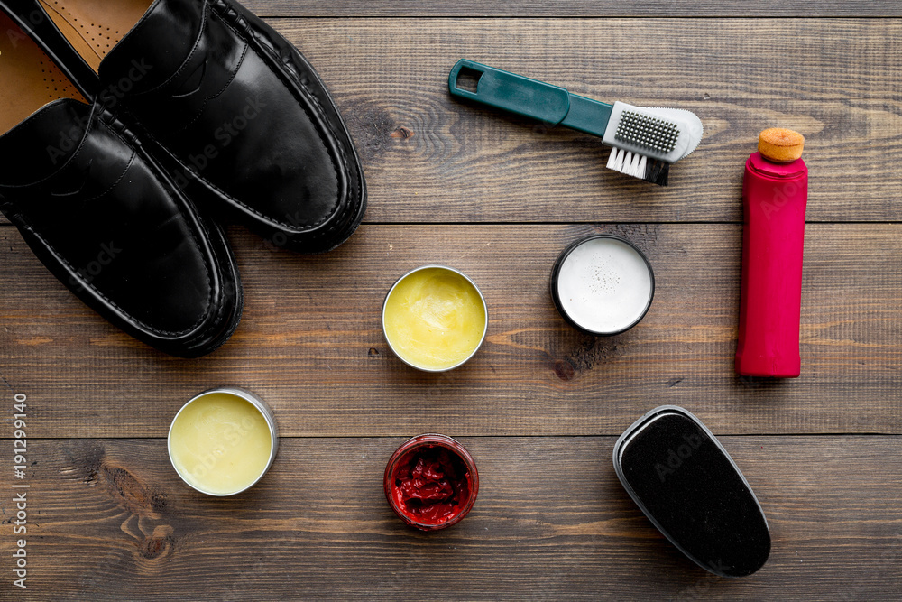 Shoe care products. Leather men shoes shoe polish brushes wax on dark wooden background top view Stock Photo Adobe Stock