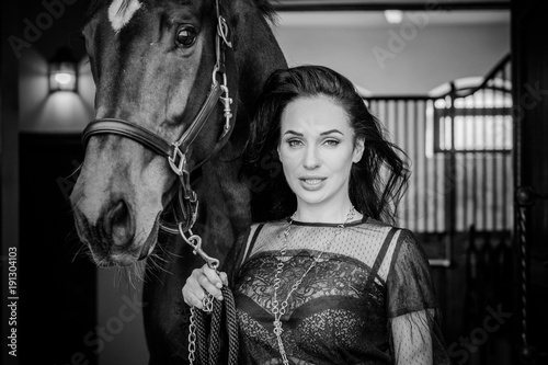  Portrait of happy beautiful nice woman and brown horse near the horse farm. Concept people and animals. Girl with an horse together at the horse house 