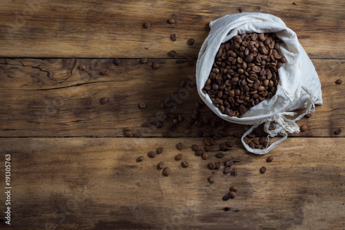 bag of coffee beans on a wooden background. Copy space. Flat lay, top view