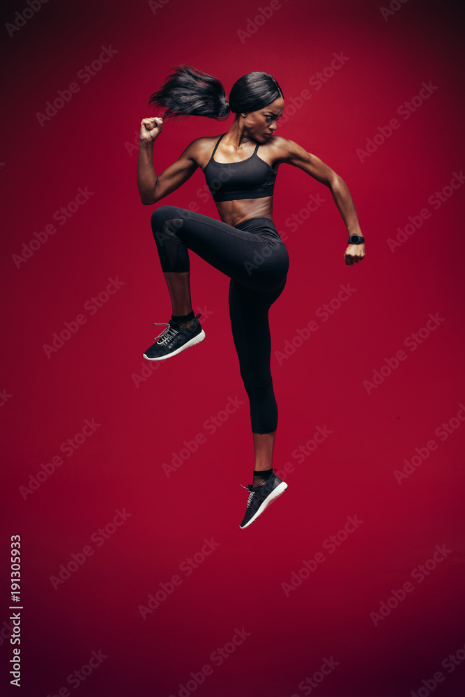 Healthy african woman jumping and exercising