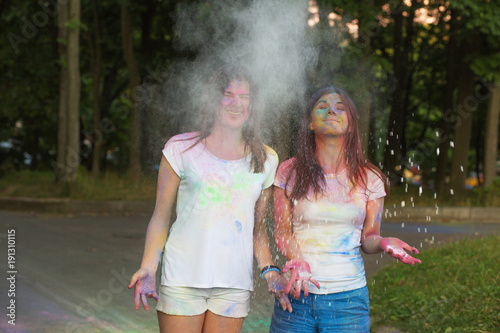 Two happy friends having fun with Holi powder in the park