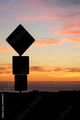 Road sign silhouette and colorful sunset
