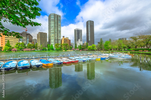 Photography Pedal boats and Tokyo skyscrapers reflecting on Shinobazu Pond in Ueno Park, a public park next to Ueno Station in central Tokyo