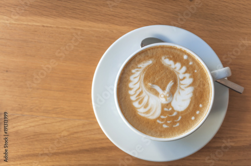 Cute little owl like latte art cappuccino espresso cup on wooden table photo