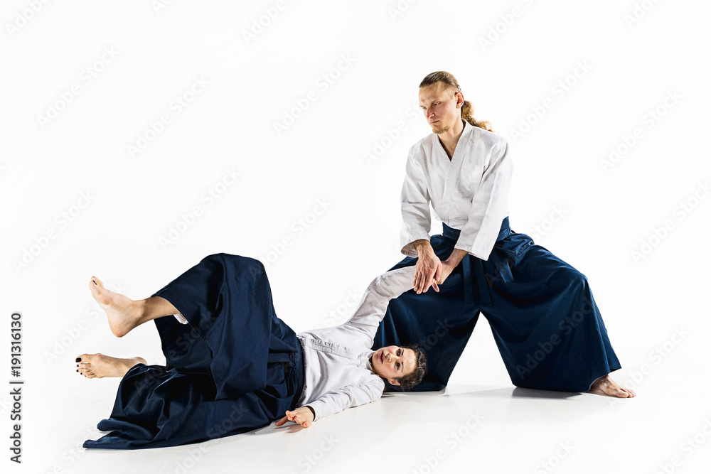 Man and woman fighting at Aikido training in martial arts school Man and woman fighting at Aikido training in martial arts school