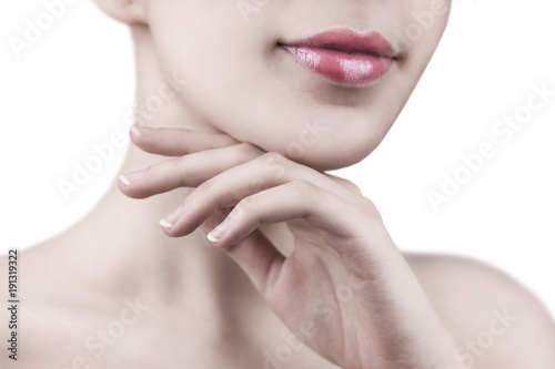 Close up of smiling attractive young woman gently touching her face with white background - cosmetic, wellness, manicure