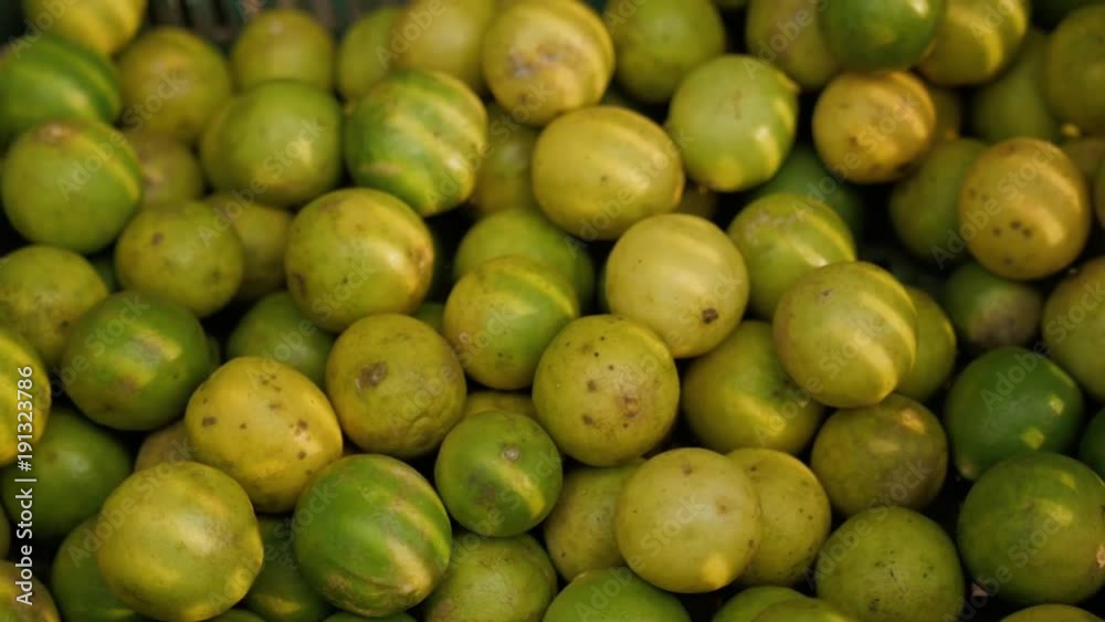 Closed up Pile of Vibrant Green Ripe Limes with Stem, on market in asia Closed up Pile of Vibrant Green Ripe Limes with Stem, on market in asia