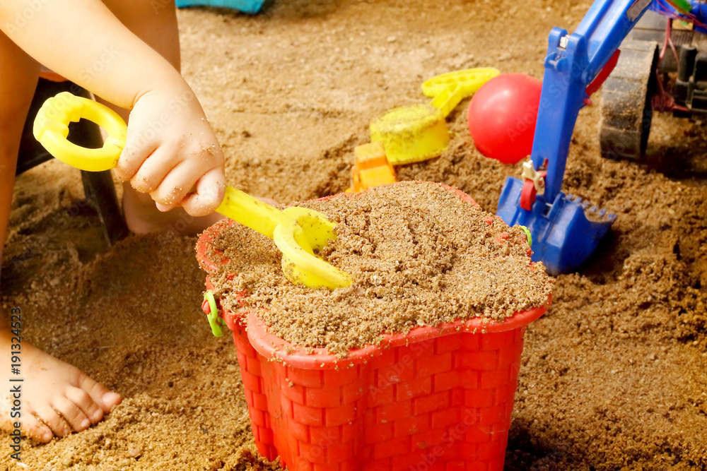 Close up of a child's hand playing sand toys. Close up of a child's hand playing sand toys.