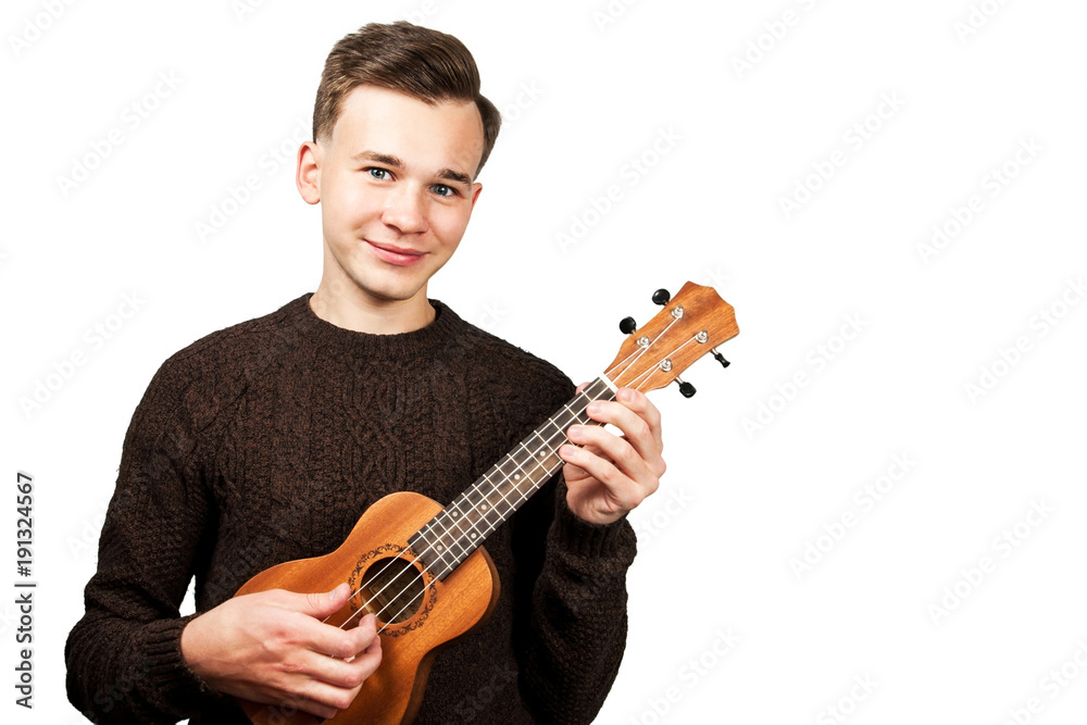 White young guy in sweater play on ukulele in his hands. Isolated on a white background.