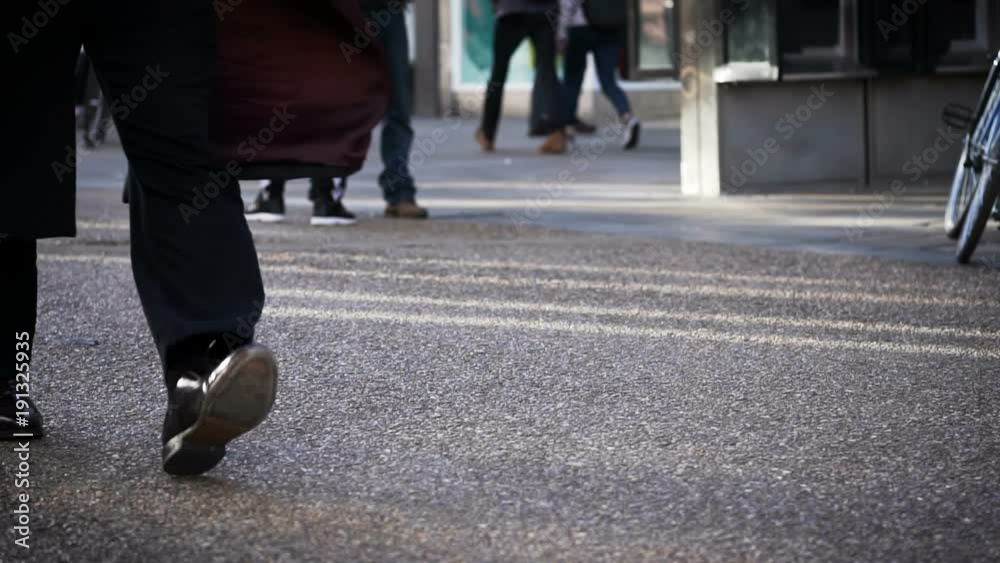 Slow motion of business man walking through a crowded street in the morning