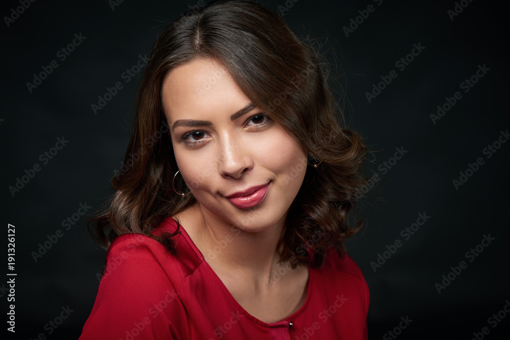 Closeup portrait of beautiful brunette woman in red shirt and wavy hair, over dark background Closeup portrait of beautiful brunette woman in red shirt and wavy hair, over dark background