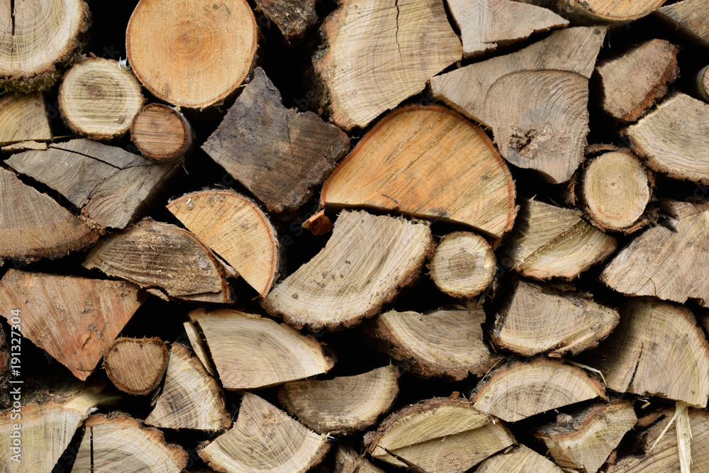 A lot of dry chopped firewood is stacked in the period of preparation for the furnace chopped logs for winter fire A lot of dry chopped firewood is stacked in the period of preparation for the furnace chopped logs for winter fire