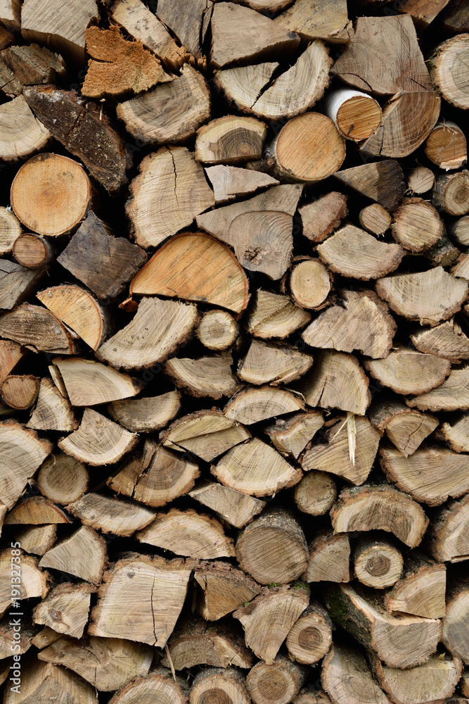 A lot of dry chopped firewood is stacked in the period of preparation for the furnace chopped logs for winter fire A lot of dry chopped firewood is stacked in the period of preparation for the furnace chopped logs for winter fire