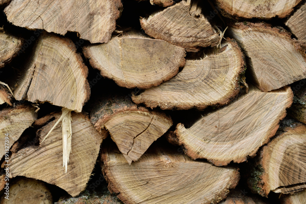 A lot of dry chopped firewood is stacked in the period of preparation for the furnace chopped logs for winter fire A lot of dry chopped firewood is stacked in the period of preparation for the furnace chopped logs for winter fire