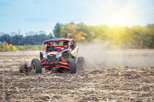 Man at the wheel of quad bike is riding around the field in the © alexlukin