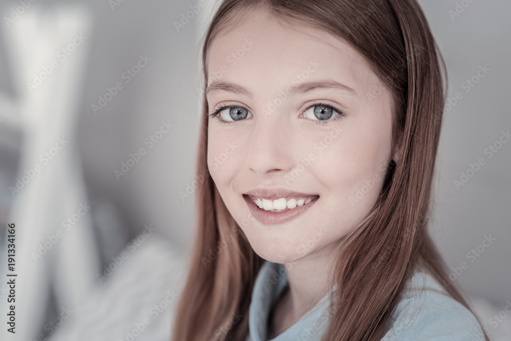 Over the moon. Beautiful long-haired grey-eyed girl smiling and emitting happiness with her smile while looking straight into the cam Over the moon. Beautiful long-haired grey-eyed girl smiling and emitting happiness with her smile while looking straight into the cam