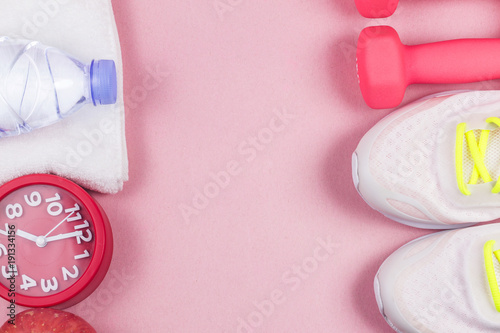 Sports shoes, dumbbell fitness, in the pink background. Different sports tools