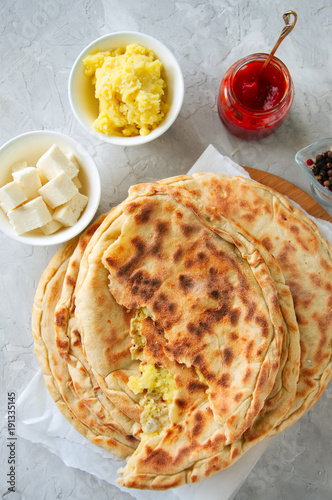 Mashed potato and sheep cheese filling flatbread on a white stone background. photo