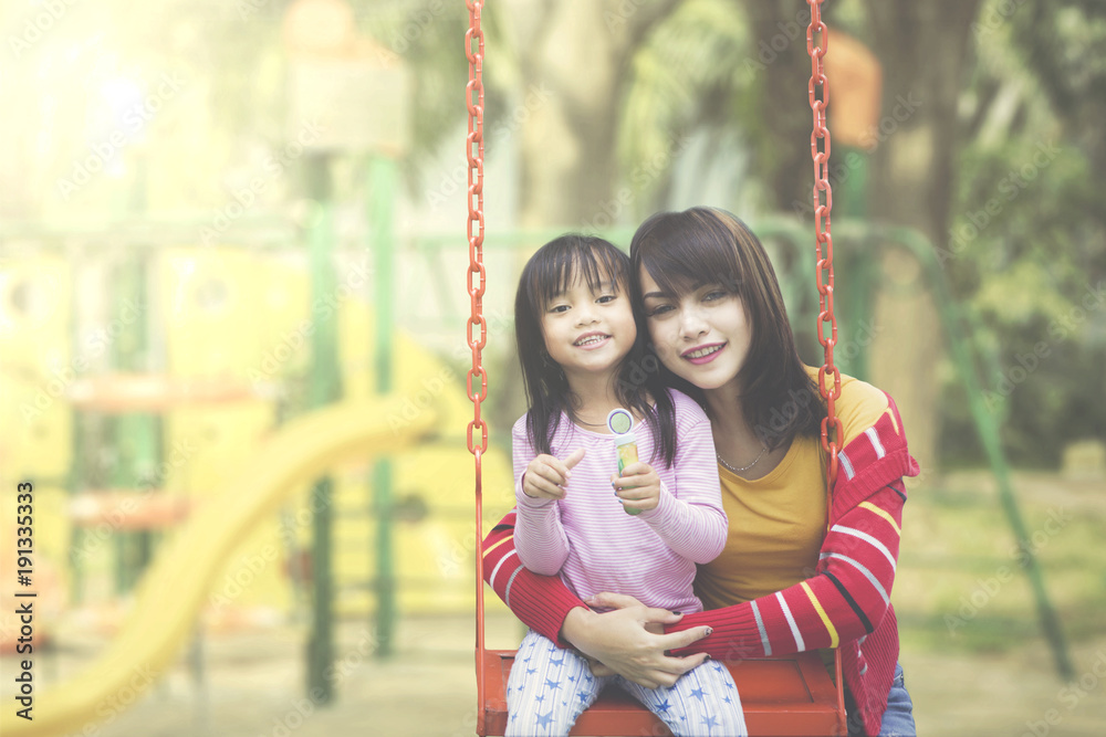 Happy mother and daughter posing at playground Happy mother and daughter posing at playground