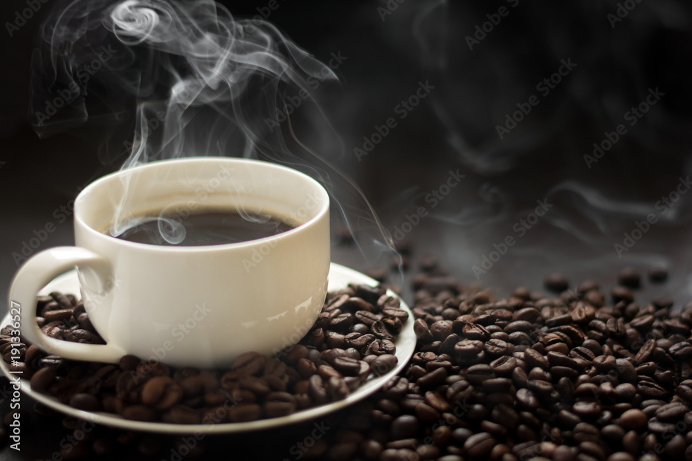 Hot cup of coffee with smoke on black background