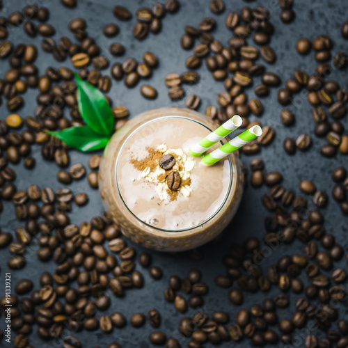 Peanut butter espresso smoothie and coffee beans on dark concrete background. Top view, space for text, close up,  selective focus. photo