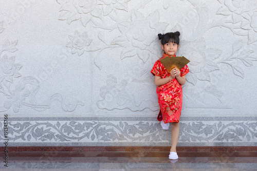 Adorable Chinese girl showing golden envelopes that contain Chinese word, Xingfu, mean Happiness for Chinese New Year bless photo