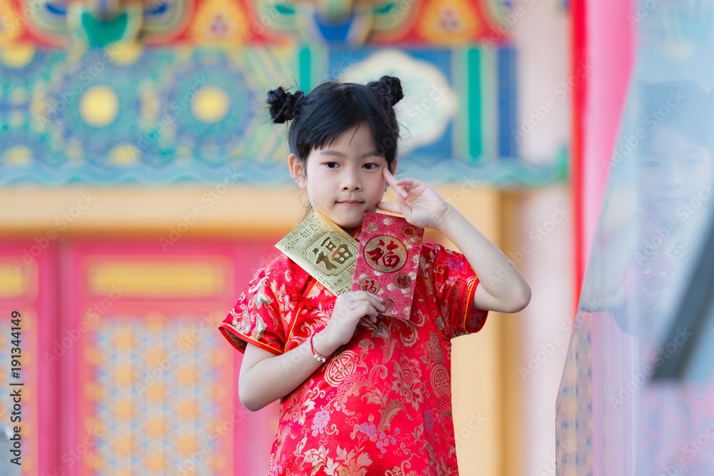 Adorable Chinese girl open golden and red envelopes that contain Chinese word, Xinfu, mean Happiness for Chinese New Year bless Adorable Chinese girl open golden and red envelopes that contain Chinese word, Xinfu, mean Happiness for Chinese New Year bless