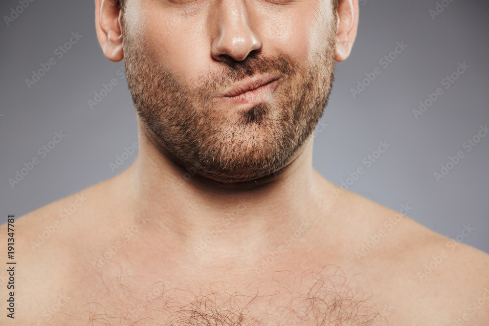 Cropped image of a young shirtless man grimacing Cropped image of a young shirtless man grimacing