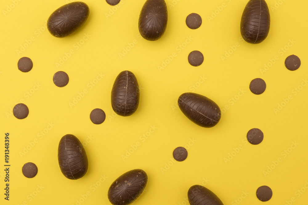 Chocolate easter eggs on a bright yellow background. Easter holiday concept