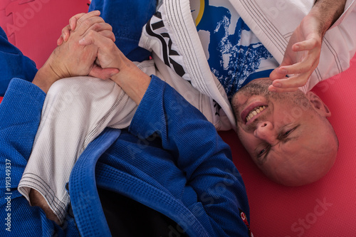 Brazylijski instruktor jiu jitsu demonstruje techniki blokowania ramion w walce w parterze